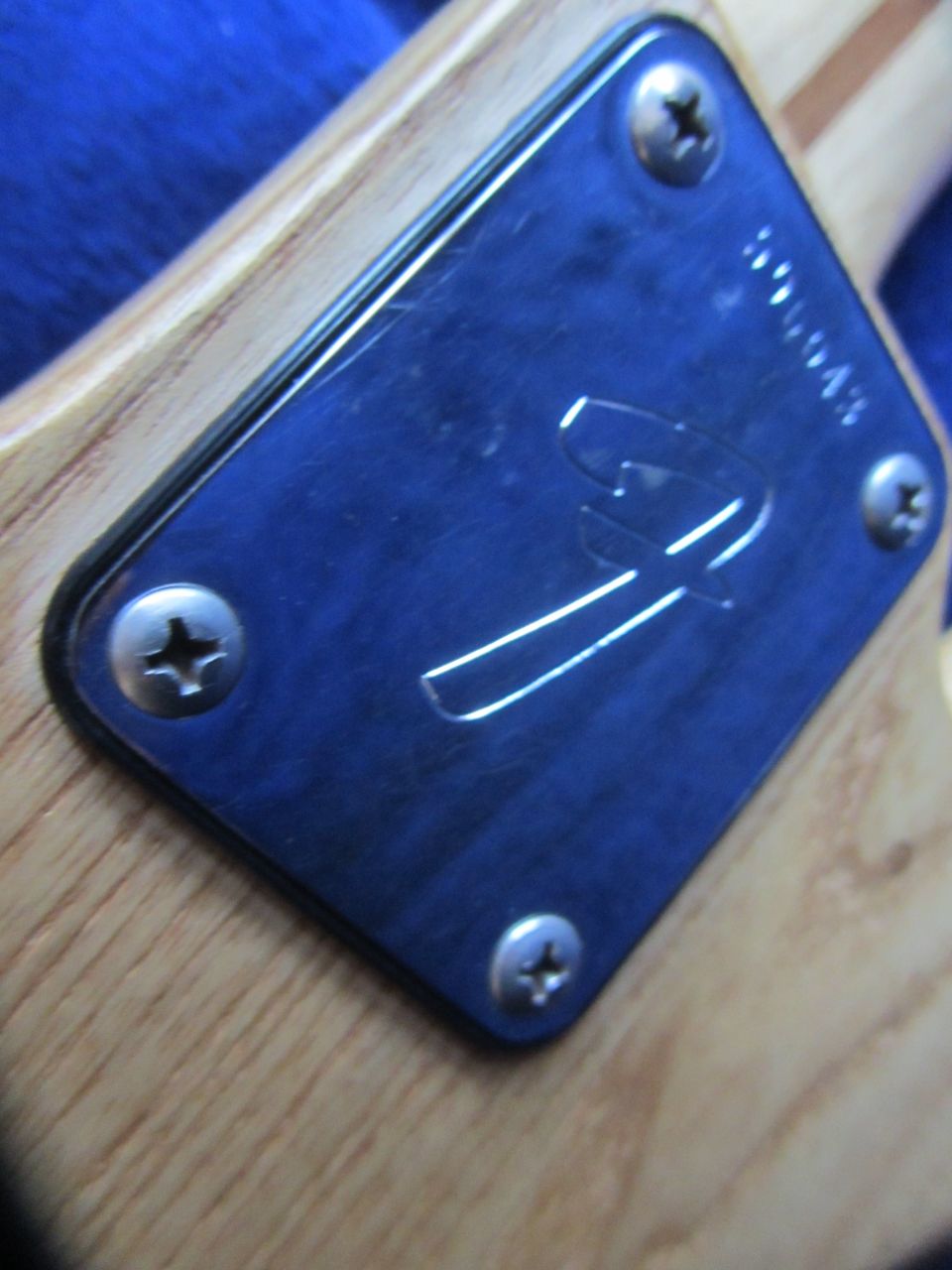 Fender logo and serial number on a guitar neck plate