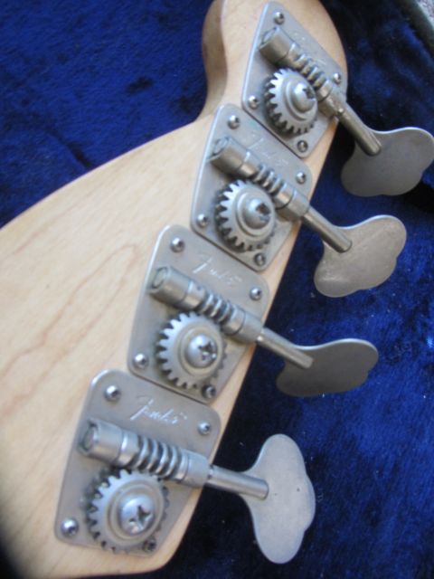 1968 Ford Mustang - Close-up of a bass guitar headstock showing four tuning machines with the Fender logo.