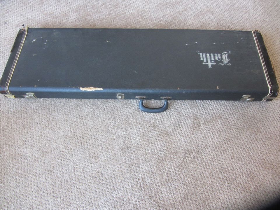 Dark guitar case with "Faith" logo