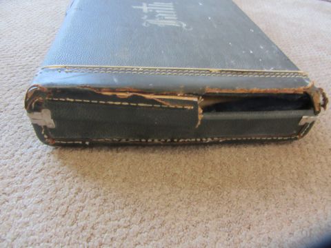 1968 Ford Mustang - A close-up view of a worn bible case, showing damage to its side and the embossed word 'Faith' on its cover.