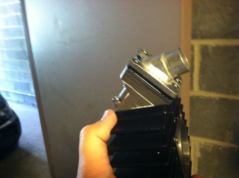 1981 Garelli Rally Sport - A chrome motorcycle engine part is held in a hand, with a brick wall in the background.