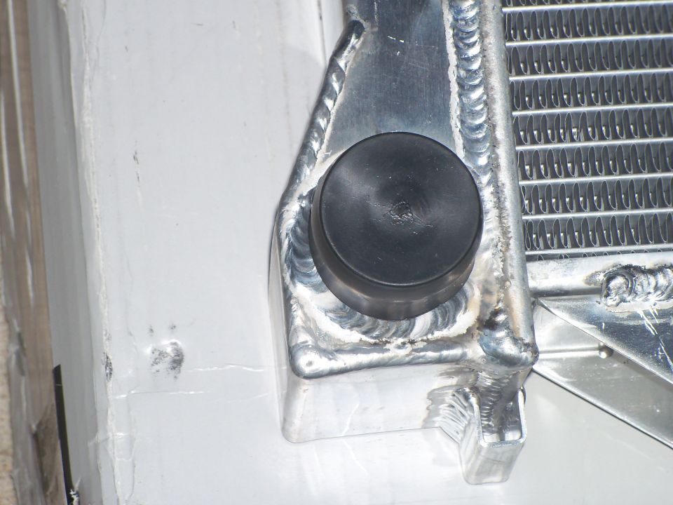 Aluminum radiator corner with TIG welds, mounting bracket and black rubber isolator bushing