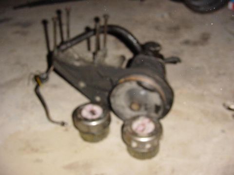 1992 Ford Bronco - A disassembled steering component, possibly from a vehicle, is shown with visible bolts and cylindrical elements.