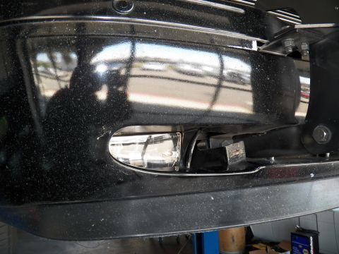 2003 Ford Crown Victoria - Close-up of a fog lamp opening in a black bumper showing a wiring connector.