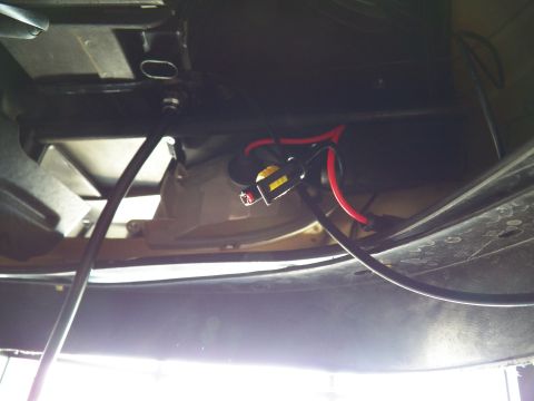 2003 Ford Crown Victoria - Close-up of a sealed HID connector and red lead tucked behind a headlight housing.