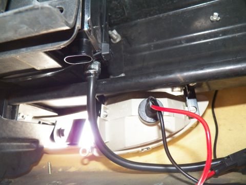 2003 Ford Crown Victoria - Underbody view showing black and red gauge wires running past a white plastic component during an install