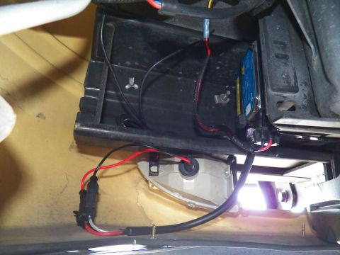 2003 Ford Crown Victoria - Ballast unit with red connectors and a glowing white housing wired into the vehicle body bay