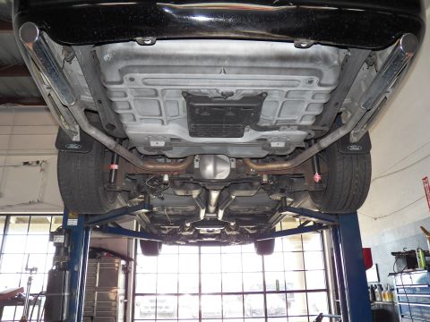 2003 Ford Crown Victoria - Underbody rear shot of a black Ford sedan, dual tailpipes and fuel tank shield visible