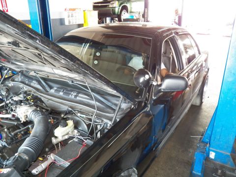 2003 Ford Crown Victoria - Black sedan with hood up, viewed from the front-left, engine and windshield visible