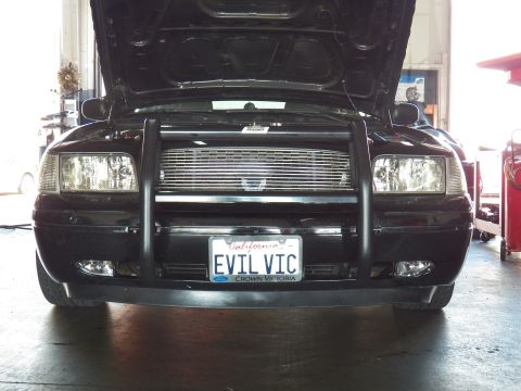 2003 Ford Crown Victoria - Head-on front of a black Crown Victoria showing push bar, fog lights and EVIL VIC plate
