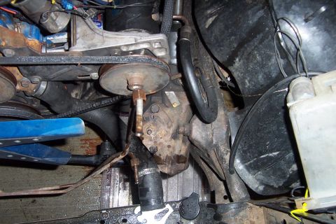1980 Ford Bronco - Close-up view of engine compartment parts, including belts, pulleys, and hoses.