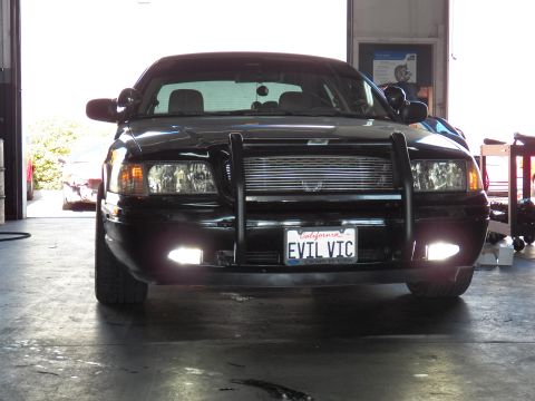 2003 Ford Crown Victoria - Wider front view; blacked-out Crown Vic, push bar, fog lights, EVIL VIC plate in shop