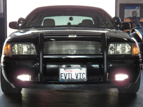 2003 Ford Crown Victoria - Tight front framing; billet grille behind brush guard, EVIL VIC California plate lit by fogs