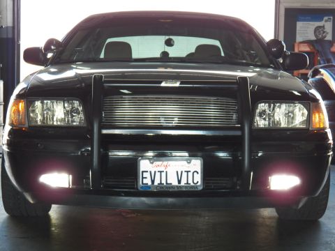 2003 Ford Crown Victoria - Service-bay front; blacked-out Crown Vic with spotlights, EVIL VIC California plate