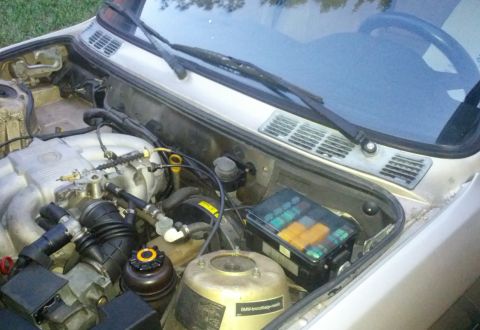 1989 BMW 3 Series - Close-up of a BMW's engine bay, the motor, fuse box, and windshield wipers.