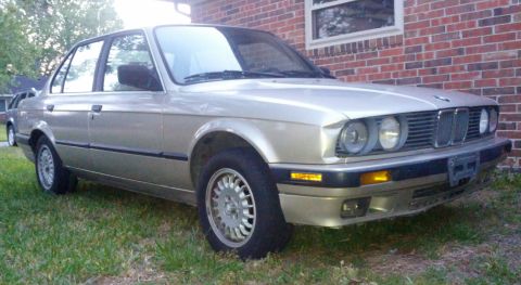 1989 BMW 3 Series - This 1989 BMW 3 Series sedan is shown from a 3/4 front angle, parked on grass next to a brick building.