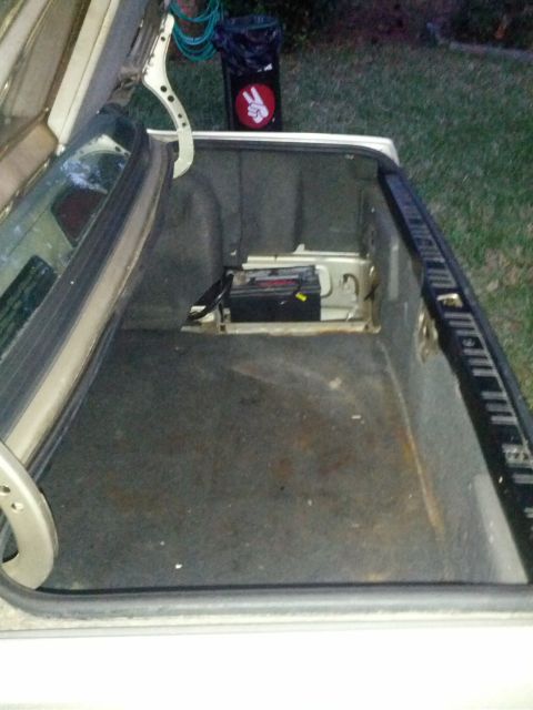 1989 BMW 3 Series - The trunk interior of a vehicle shows the battery and surrounding components.
