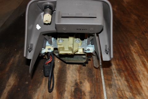 2003 Ford Crown Victoria - A disassembled car interior part is shown against a wooden background.