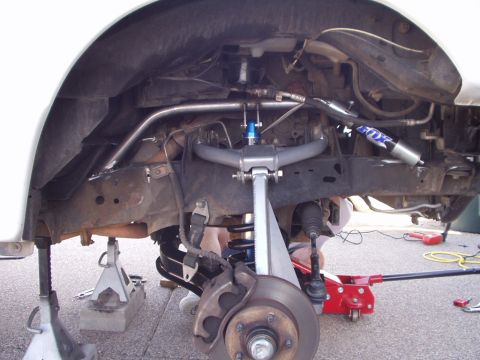 1993 Ford Bronco - The front suspension of a vehicle is shown with a Fox shock absorber and jack stands supporting it.
