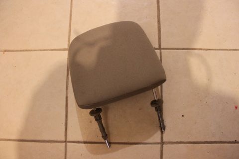 2003 Ford Crown Victoria - A detached headrest lies on a tiled surface, with a website watermark visible at the bottom right.