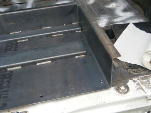 1988 Ford E350 - A metal shelving unit is installed in the cargo area of a van, with a roll of paper towels nearby.