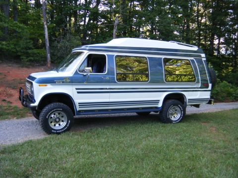 1988 Ford E350 - This 1988 Ford E350 van is modified with a lift kit and off-road tires, parked outdoors.