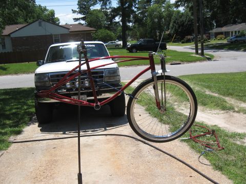 1994 Ford Bronco - A white Ford F-Series truck is parked behind a red bicycle frame that is mounted on a stand.