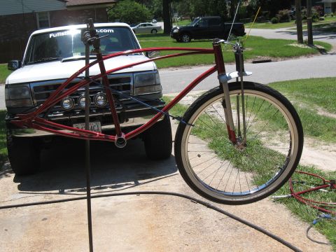 1994 Ford Bronco - A red bicycle frame is positioned in front of a white 1994 Ford Bronco.