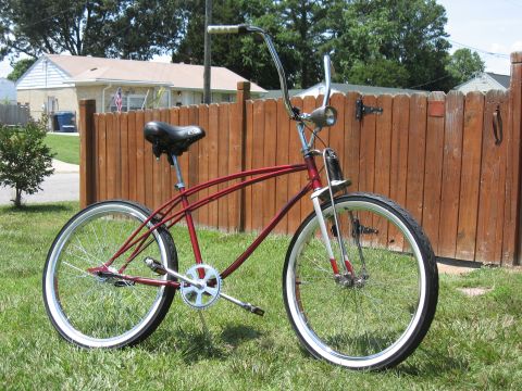 1994 Ford Bronco - A classic red cruiser bicycle with a distinctive frame design is shown outdoors.