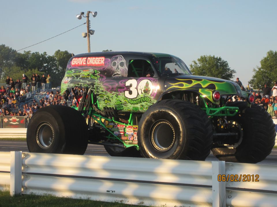 Monster truck Grave Digger with "30th Anniversary" text and green flames, seen from the side
