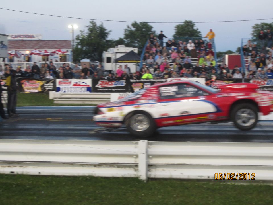 Red and white drag racing car on track, side view. Date stamp 06/02/2012