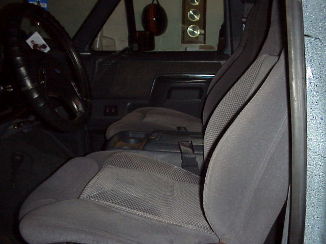 Gray cloth front bucket seats in a Ford truck seen through the open passenger door