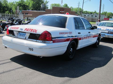 1991 Ford LTD Crown Victoria - white Cayuga County Sheriff Ford Crown Victoria cruiser, unit 720, viewed from the rear three-quarter beside motorcycles.
