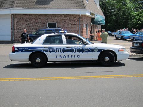 1991 Ford LTD Crown Victoria - white East Hartford Police Traffic Crown Victoria parked along a roadway with other cruisers behind.
