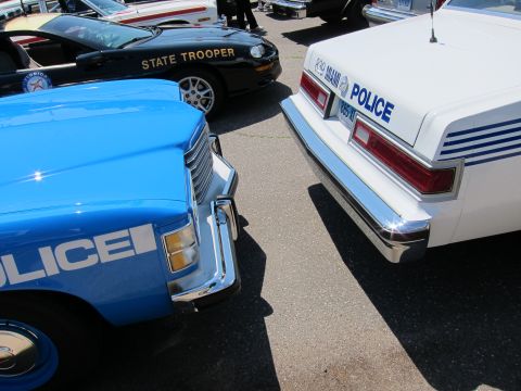 1991 Ford LTD Crown Victoria - Close-up of the front ends of parked police cars, including Miami Police and State Trooper markings.