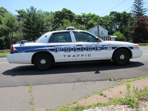 1991 Ford LTD Crown Victoria - Side profile of a white-and-blue East Hartford Police Traffic Crown Victoria parked along a road.