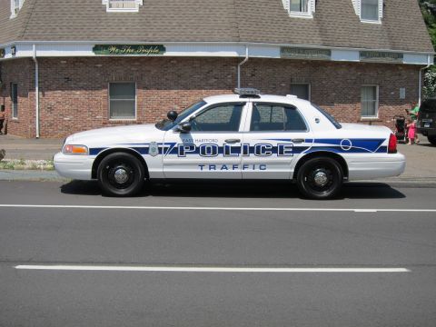 1991 Ford LTD Crown Victoria - East Hartford Police Traffic Crown Victoria parked in profile along the curb in front of a brick building.