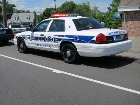 1991 Ford LTD Crown Victoria - rear three-quarter view of an East Hartford Police Traffic Crown Victoria with its light bar lit, parked on a street.