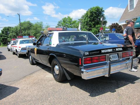 1991 Ford LTD Crown Victoria - rear view of a black-and-white Chevrolet Caprice Highway Patrol car marked unit 154 with a Wyoming plate.