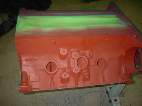 1967 Ford Mustang - Engine block painted orange with masking tape applied to the top edge for painting.