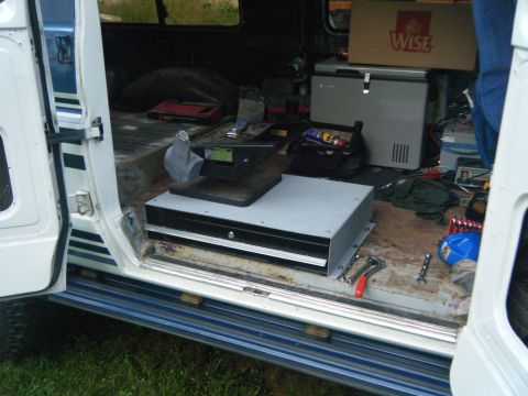 1988 Ford E350 - The interior of a van is filled with tools and equipment, including a portable cooler and a bench grinder.