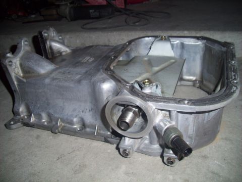 2003 Hyundai Tiburon - This is an oil pan, likely from a vehicle, with a threaded fitting and a sensor attached. The registry information may be incorrect.