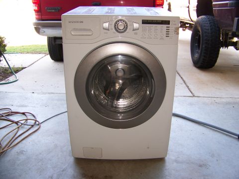 2000 Jeep Wrangler - A washing machine is parked in front of two trucks, one red and one lifted.