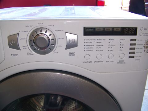 2000 Jeep Wrangler - Control panel of a white washing machine displays various wash cycle options and a digital timer.