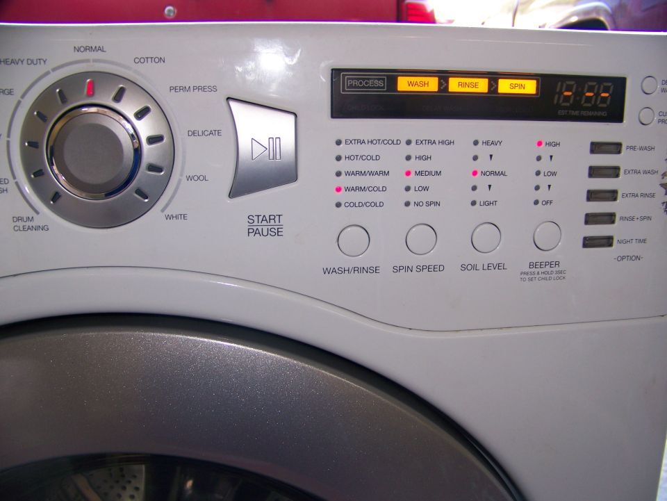 Washing machine control panel with cycle selector dial, digital display, and buttons for wash/rinse, spin speed, soil level, and beeper