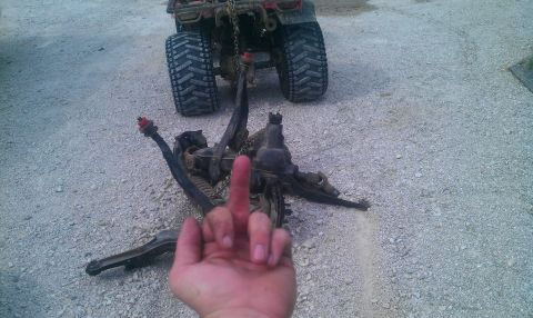 1987 Ford Bronco - Someone is showing the middle finger over disassembled suspension parts with an ATV behind them.