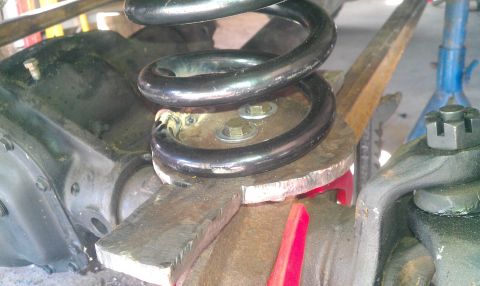 1987 Ford Bronco - Close-up view of vehicle suspension components, including a coil spring and differential housing.