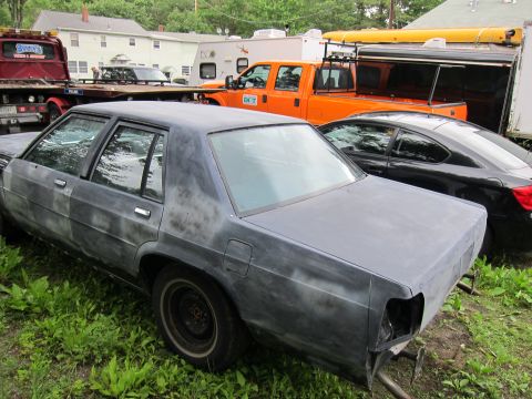 1991 Ford LTD Crown Victoria - Primer gray 1991 Ford Crown Victoria LTD sedan parked outdoors with other vehicles.