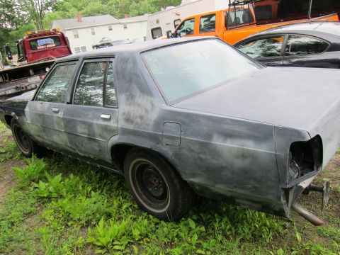 1991 Ford LTD Crown Victoria - This Ford Crown Victoria is in primer and appears to be undergoing restoration, with other vehicles visible in the background.