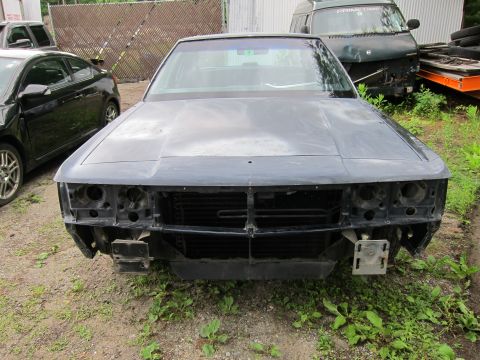 1991 Ford LTD Crown Victoria - A car with its front end disassembled sits in a yard next to a van.